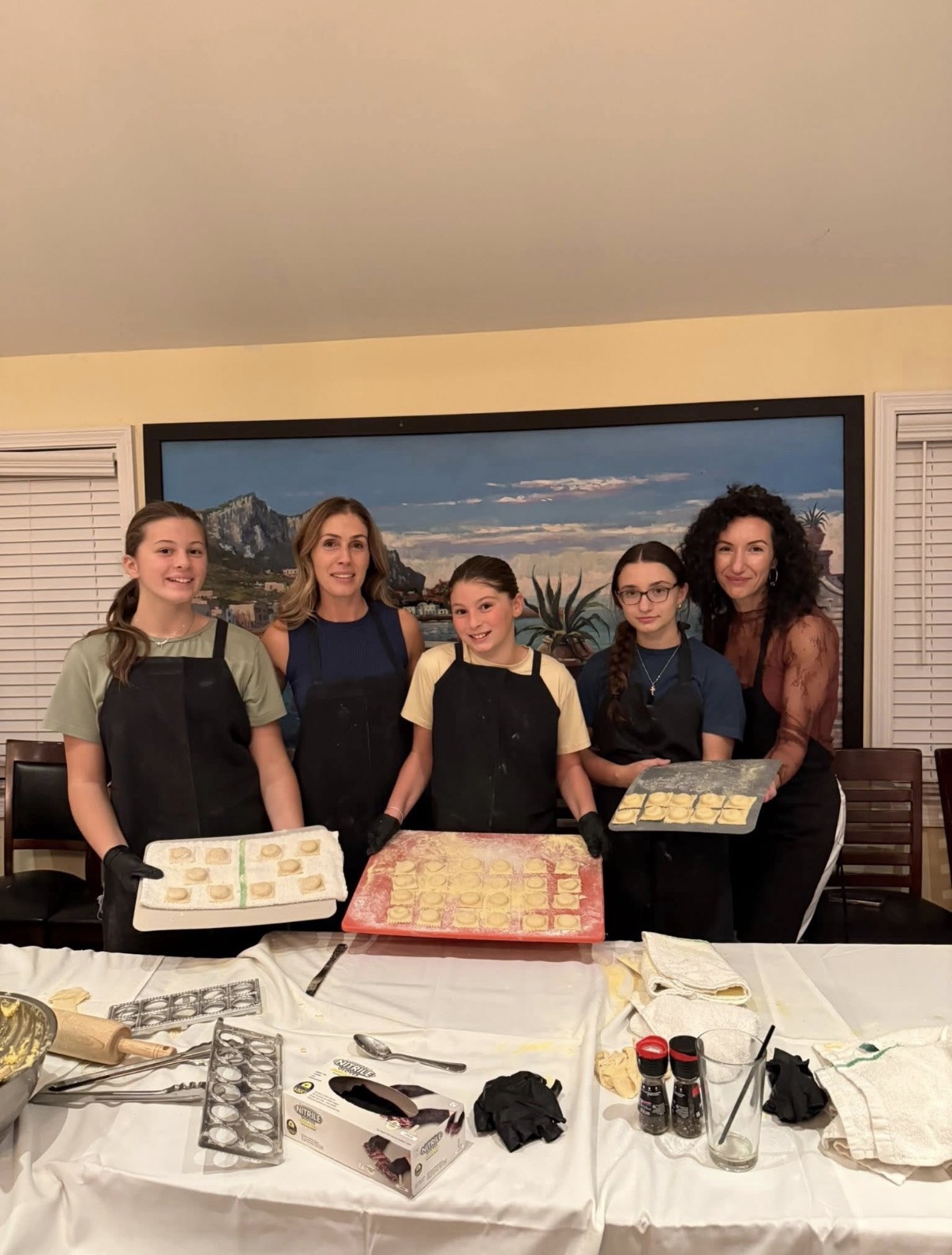 Family showing off trays of fresh ravioli together