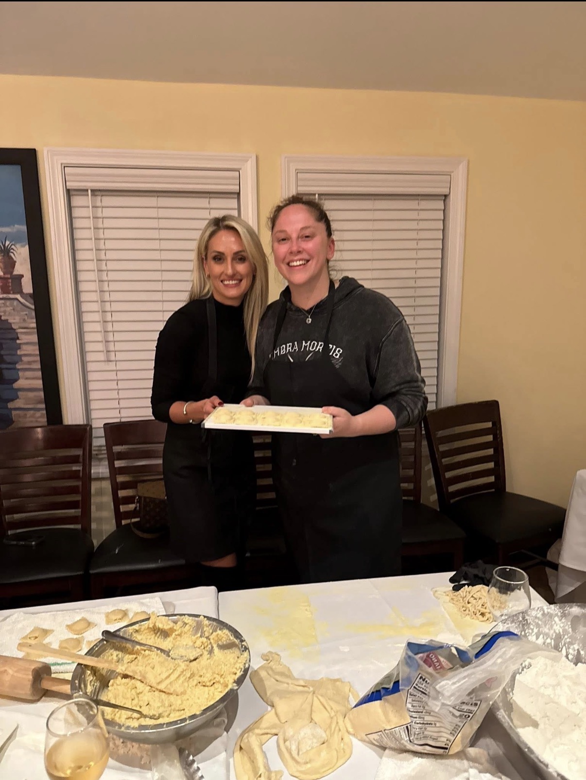Guests proudly holding a tray of homemade ravioli